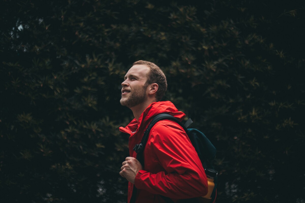 a guy in a red jacket go backpacking